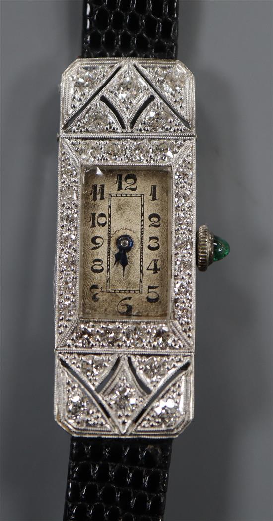 A ladys late 1920s 18ct white gold and diamond set rectangular cocktail watch, with cabochon emerald set winding crown.